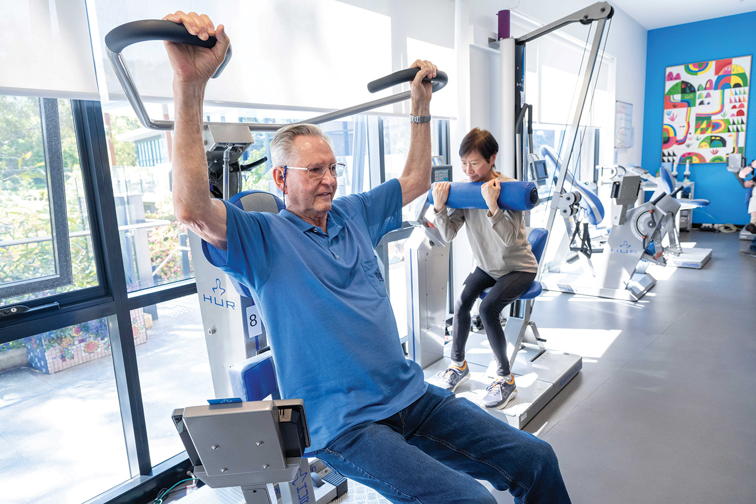 Two persons training with HUR gym machines