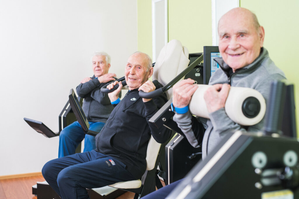 A group of elderly man rehabilitating with HUR gym machines.
